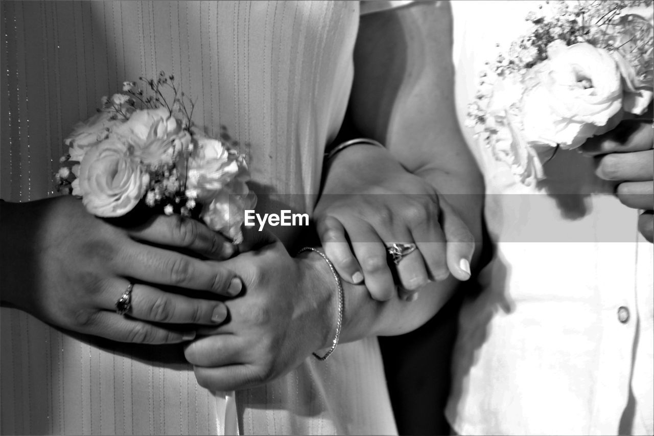 Midsection of homosexual couple with bouquet