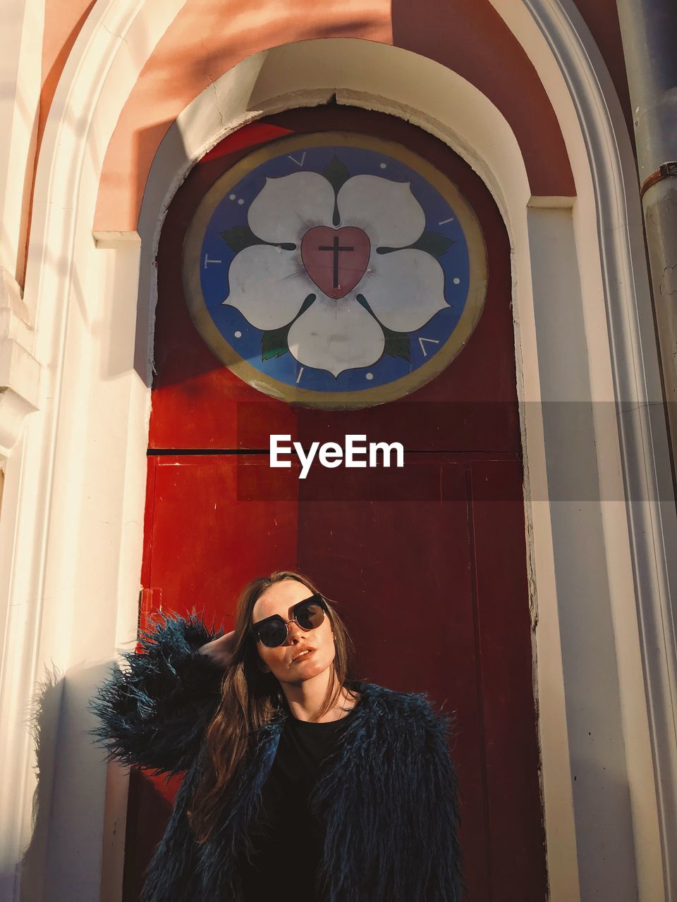 Portrait of woman wearing sunglasses against church 
