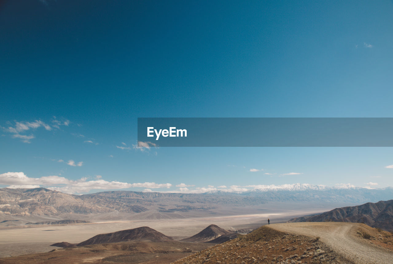 Scenic view of desert against blue sky