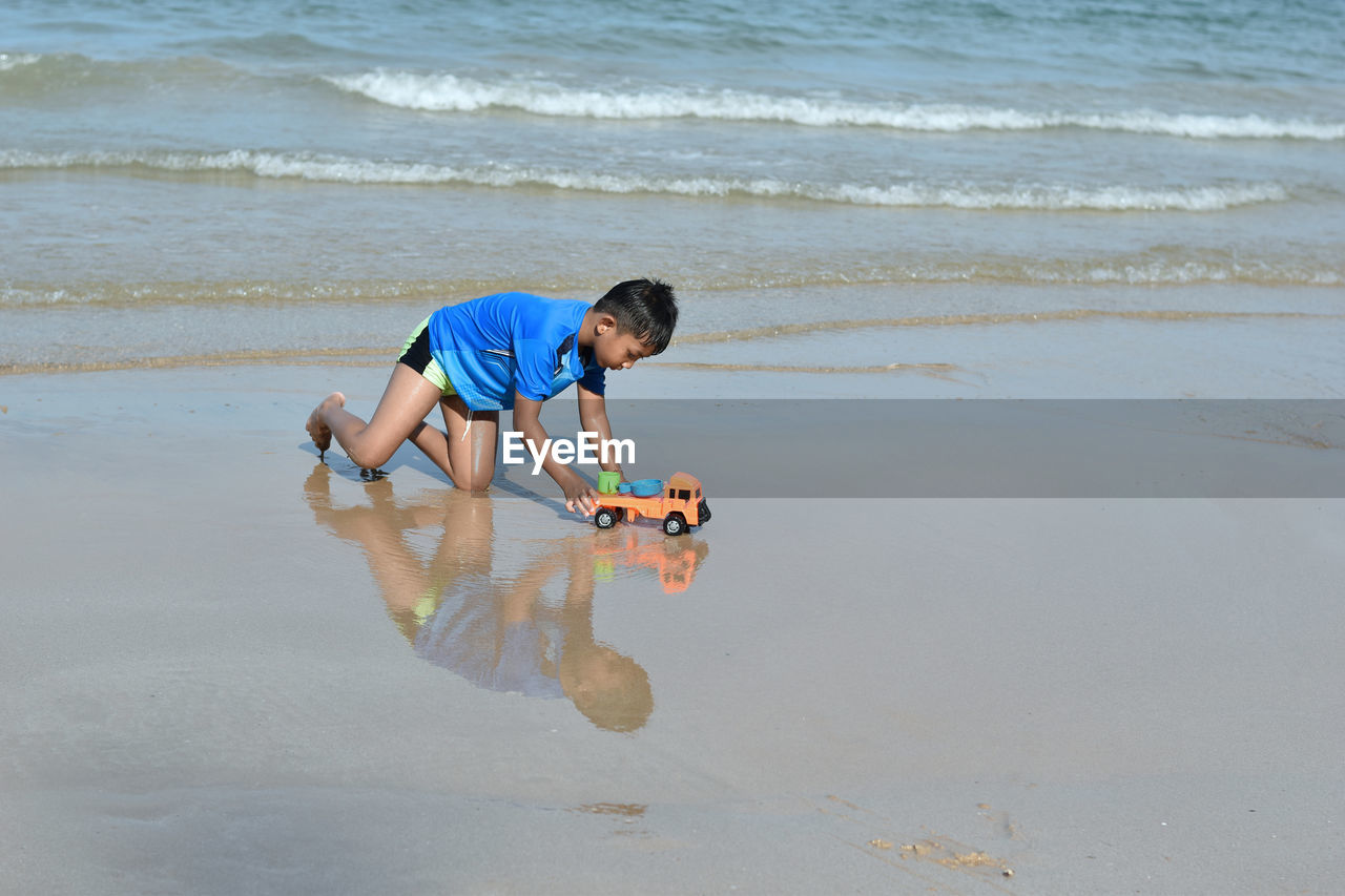 FULL LENGTH OF BOY ON BEACH