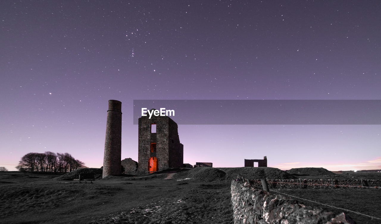 Low angle view of old ruin against clear sky at night