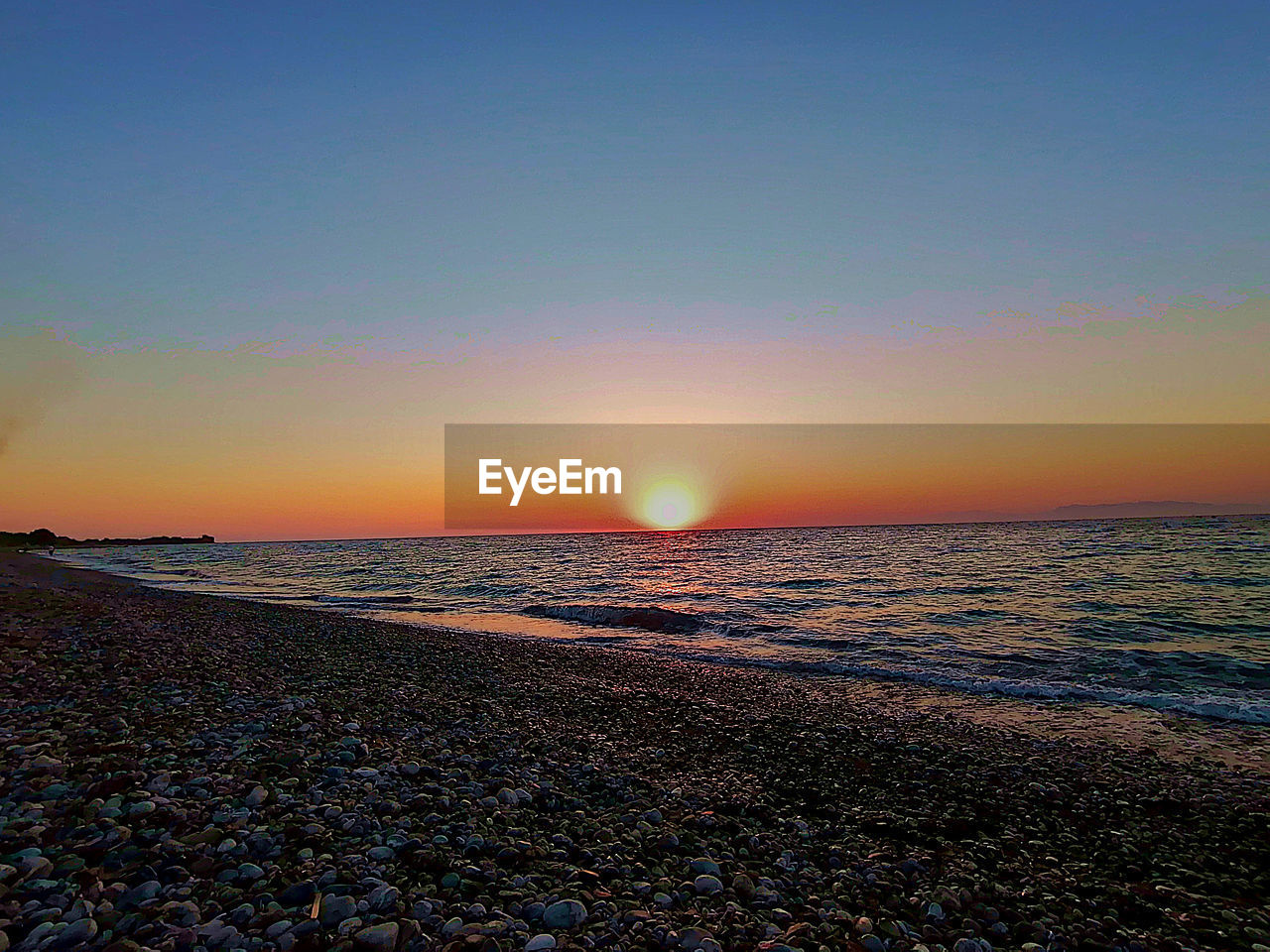 SCENIC VIEW OF BEACH DURING SUNSET