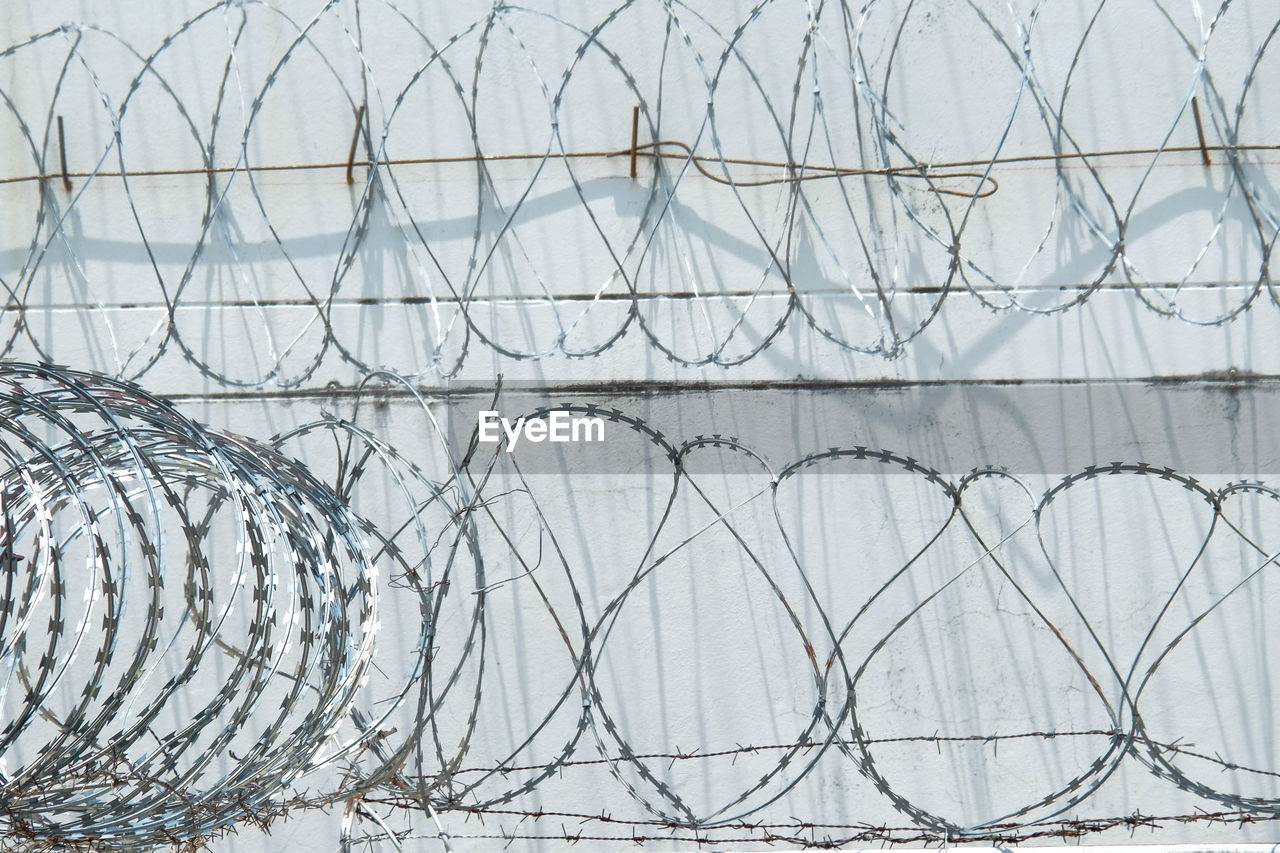 CLOSE-UP OF BARBED WIRE FENCE ON WINDOW