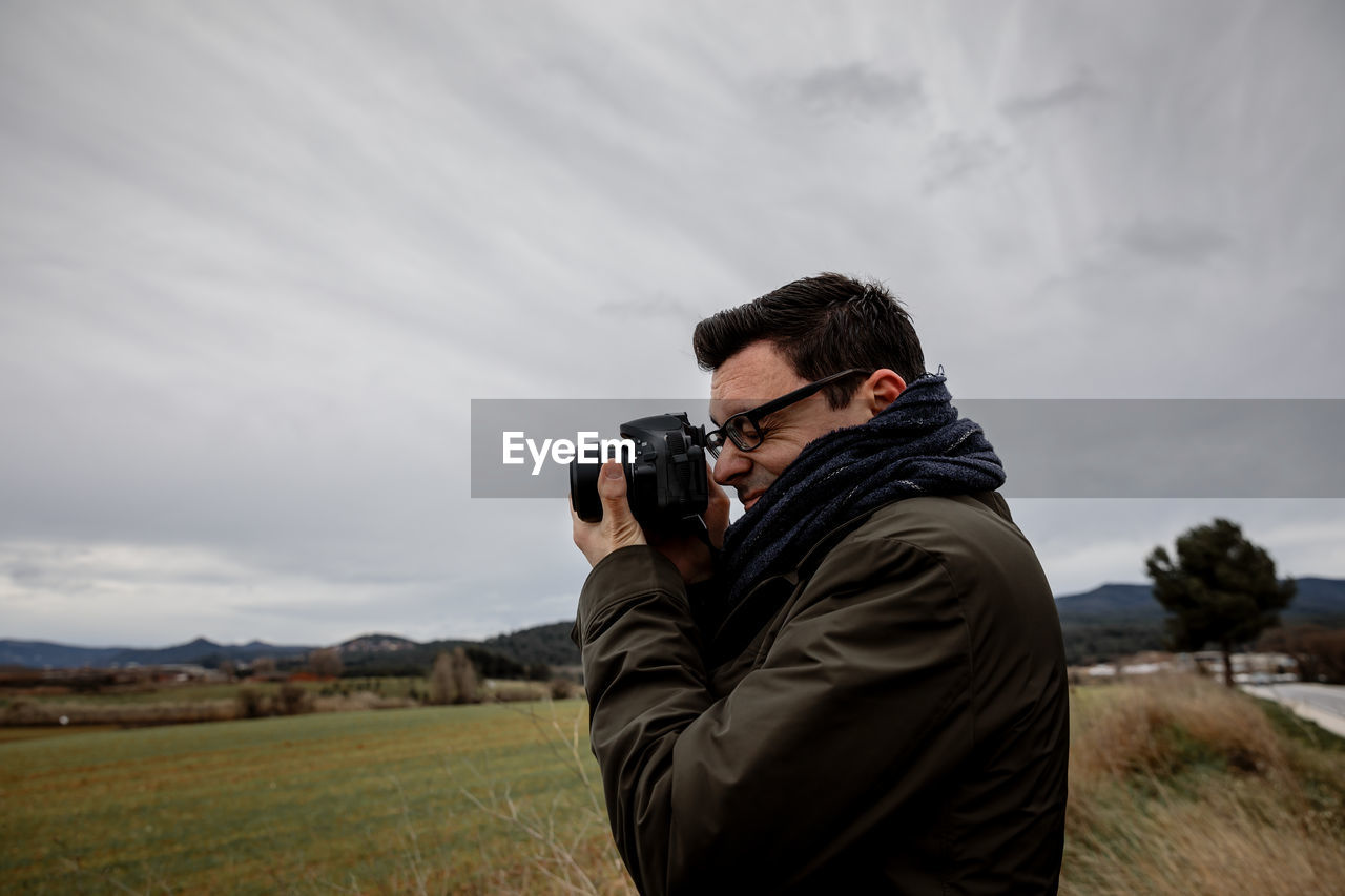 Man photographing against sky