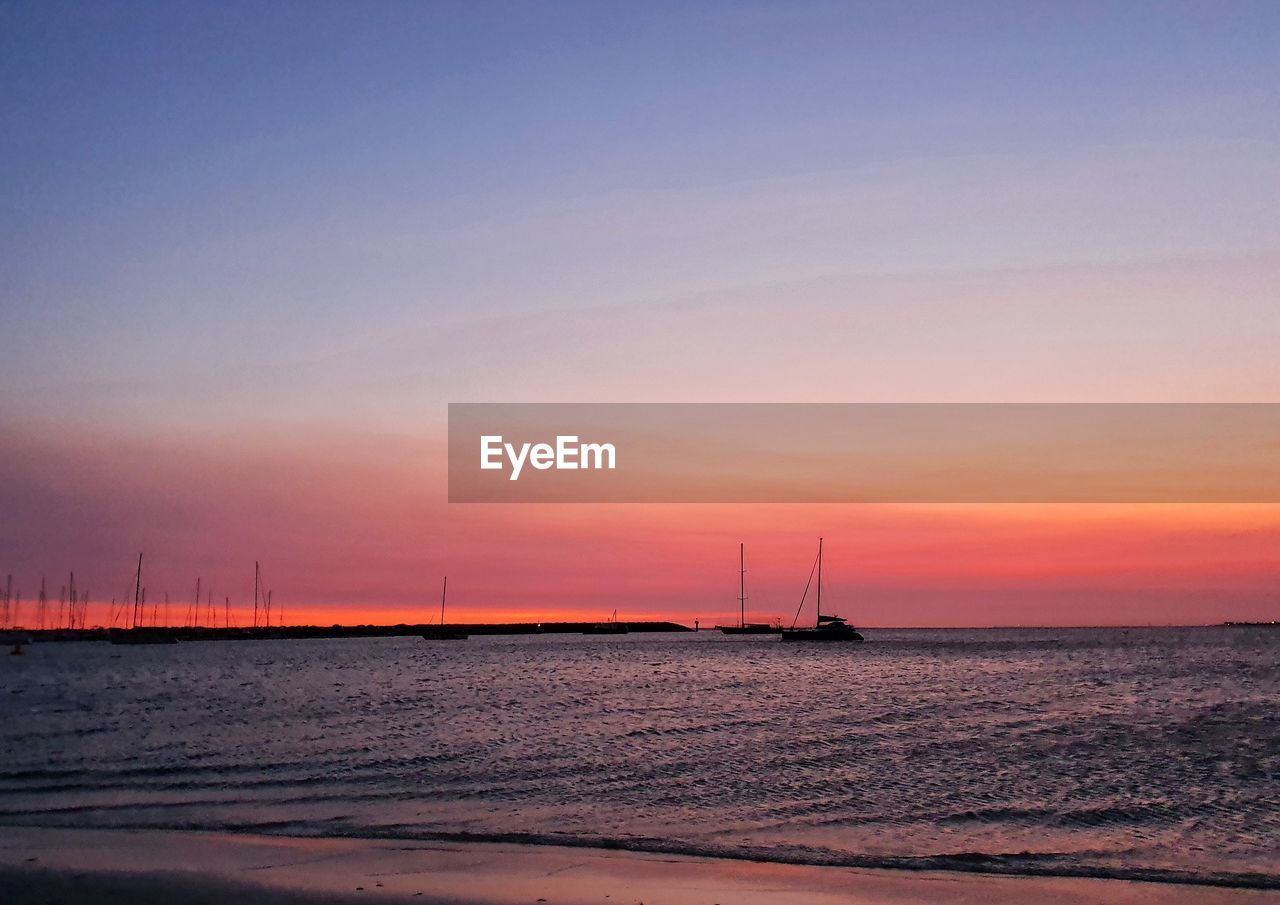 SAILBOAT ON SEA AGAINST SKY DURING SUNSET