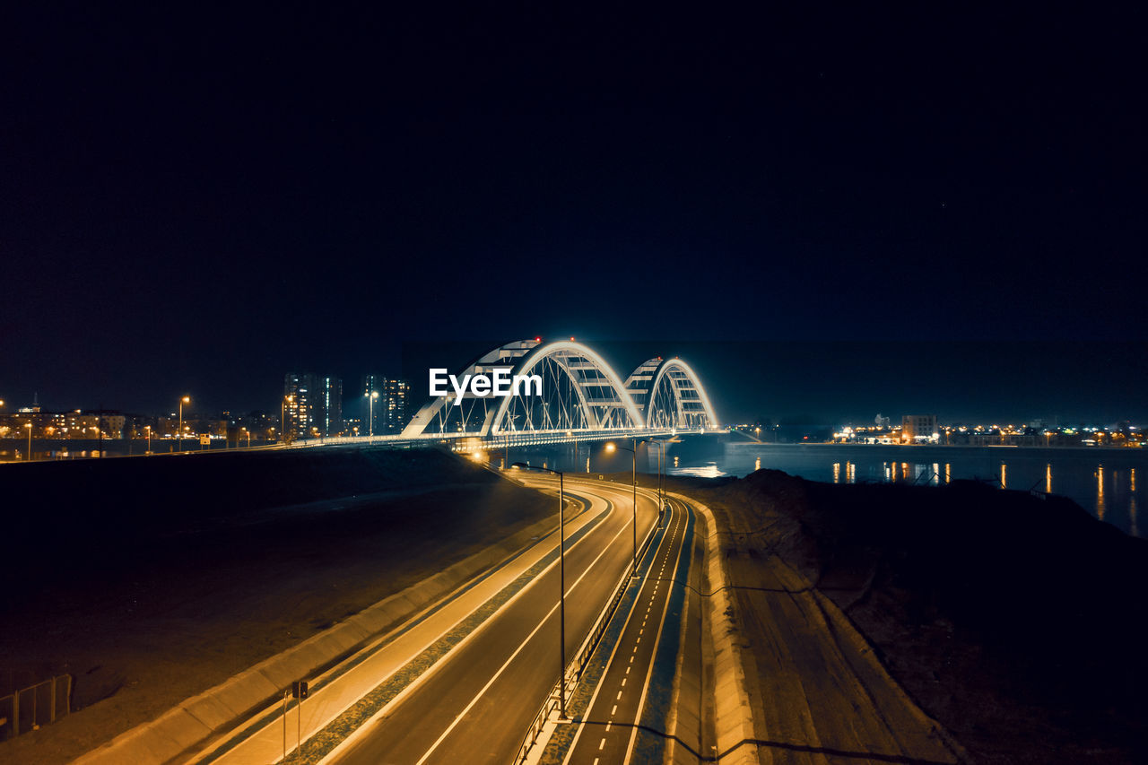 Light trails on road against sky at night