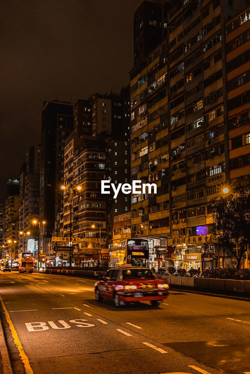 Illuminated city street and buildings at night