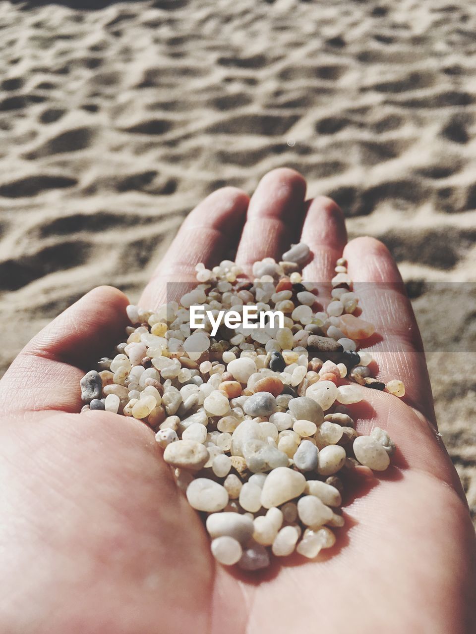 CLOSE-UP OF HAND HOLDING SAND