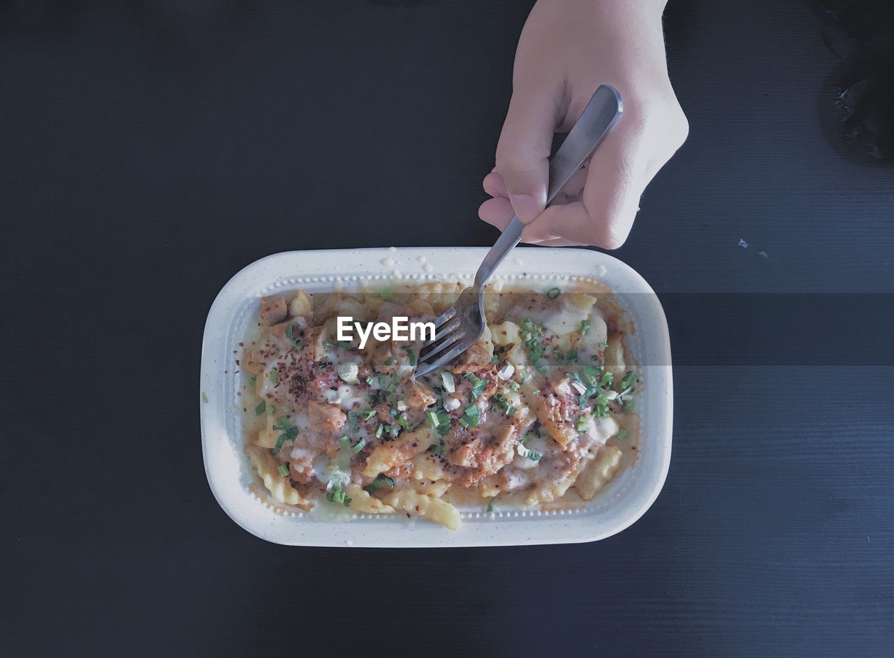 Cropped hand of woman having food on table