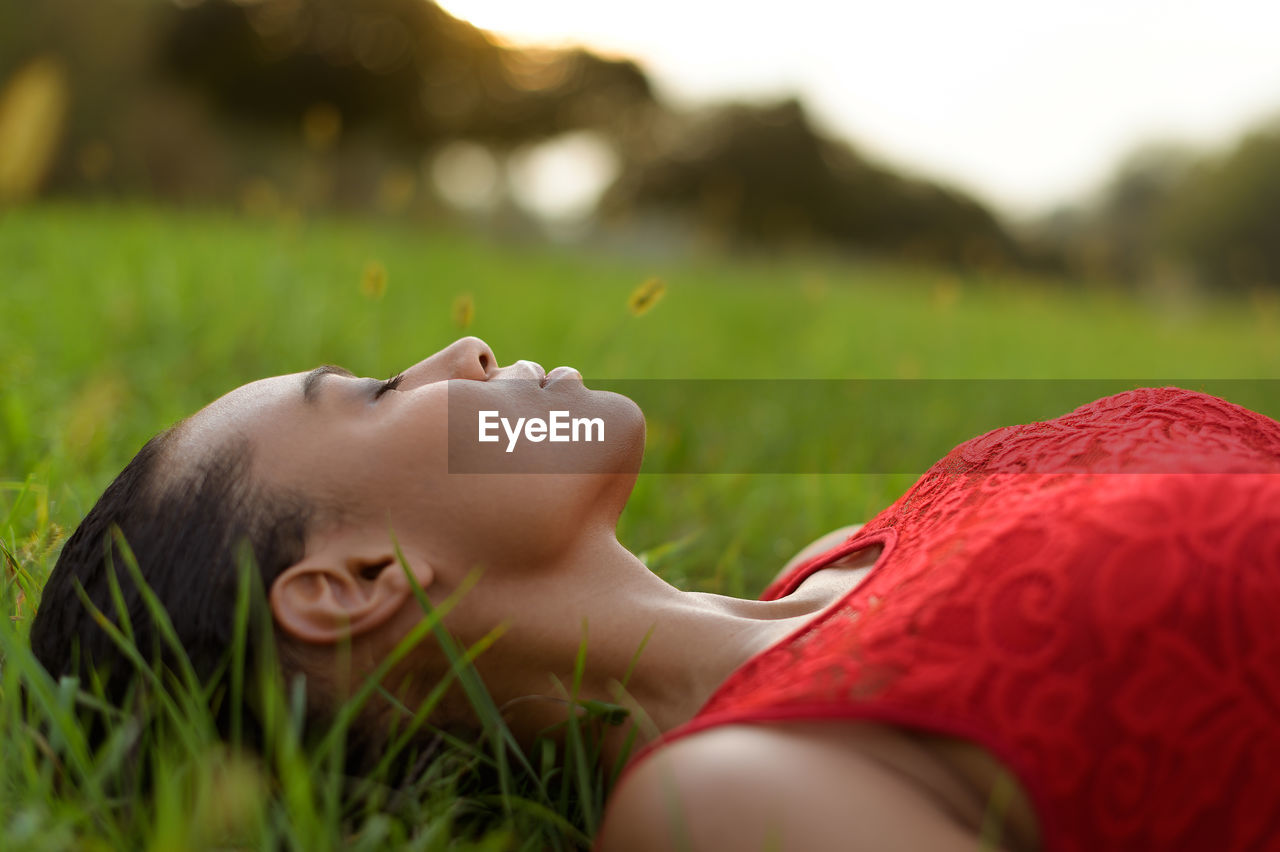 MIDSECTION OF WOMAN LYING ON FIELD