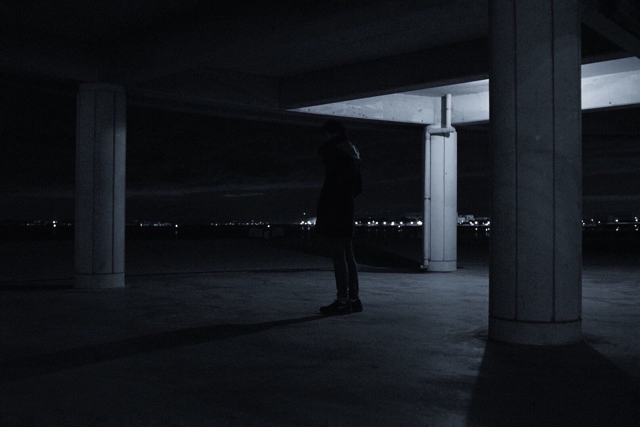 MAN IN ILLUMINATED CORRIDOR