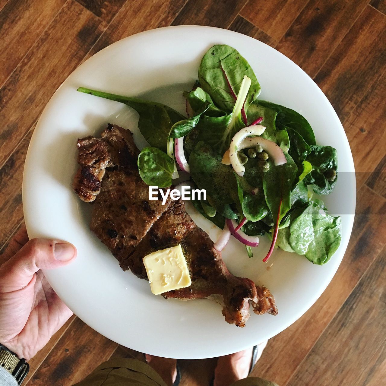 HIGH ANGLE VIEW OF HAND HOLDING SALAD