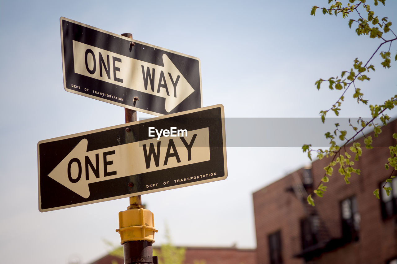 Low angle view of road sign against clear sky