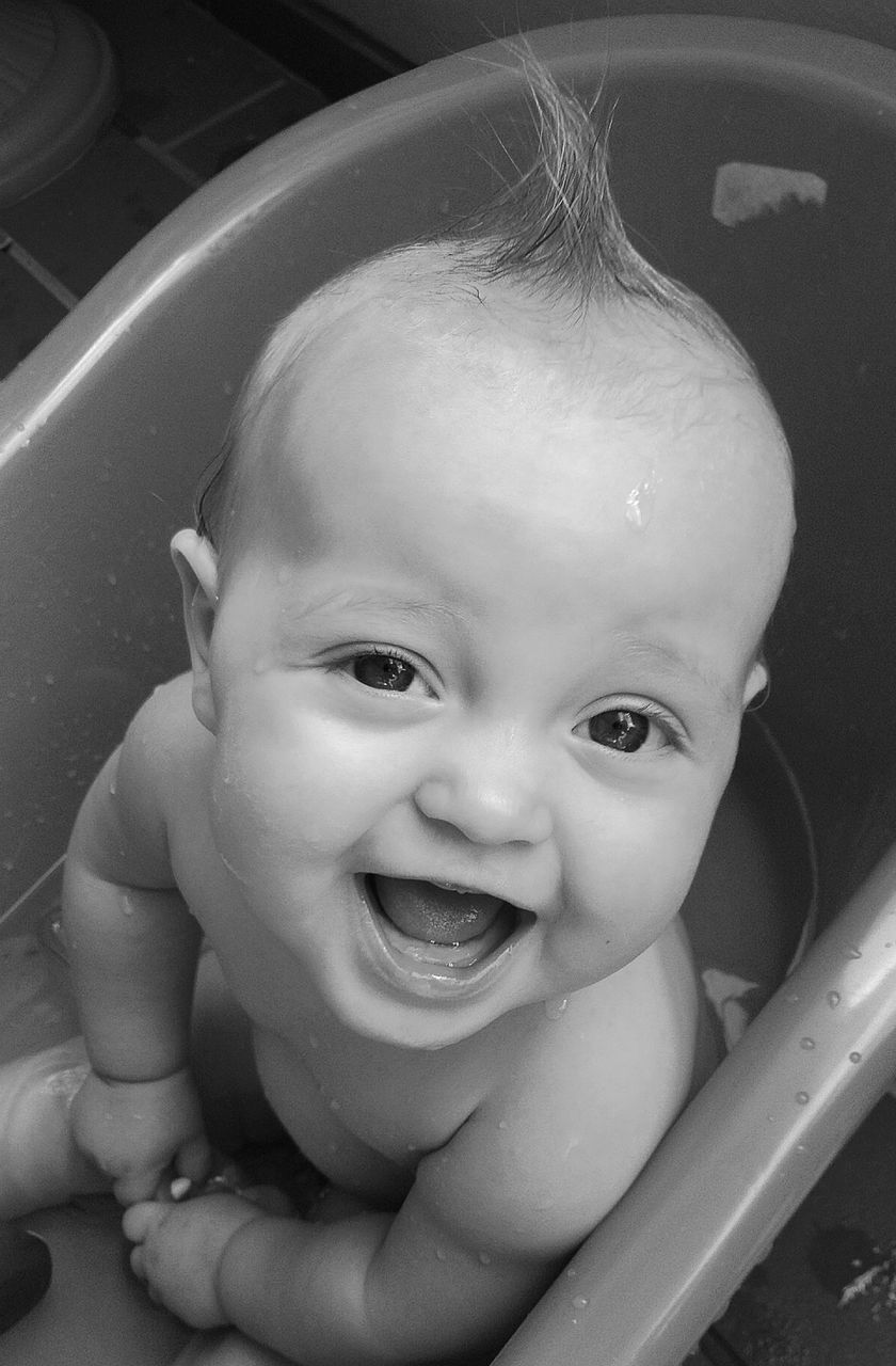 Baby girl in plastic bathtub