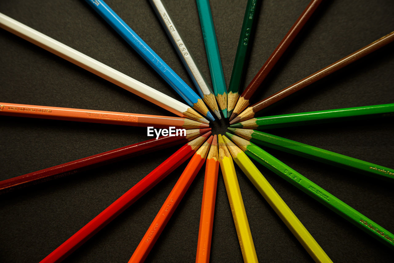 HIGH ANGLE VIEW OF COLORED PENCILS ON TABLE