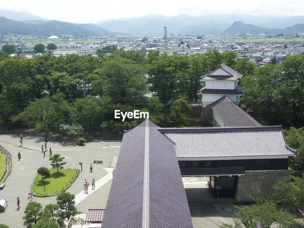 People at aizuwakamatsu castle against cityscape