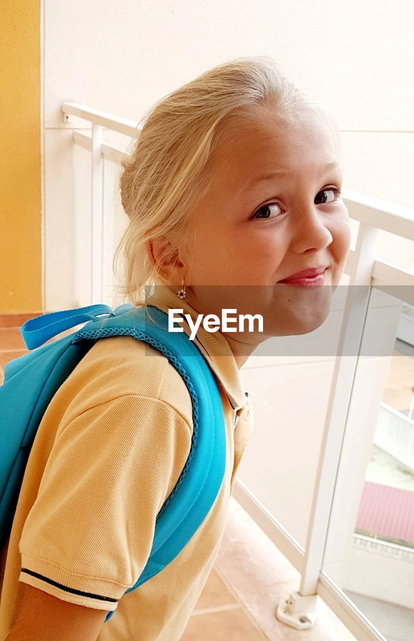 PORTRAIT OF CUTE GIRL STANDING AT HOME