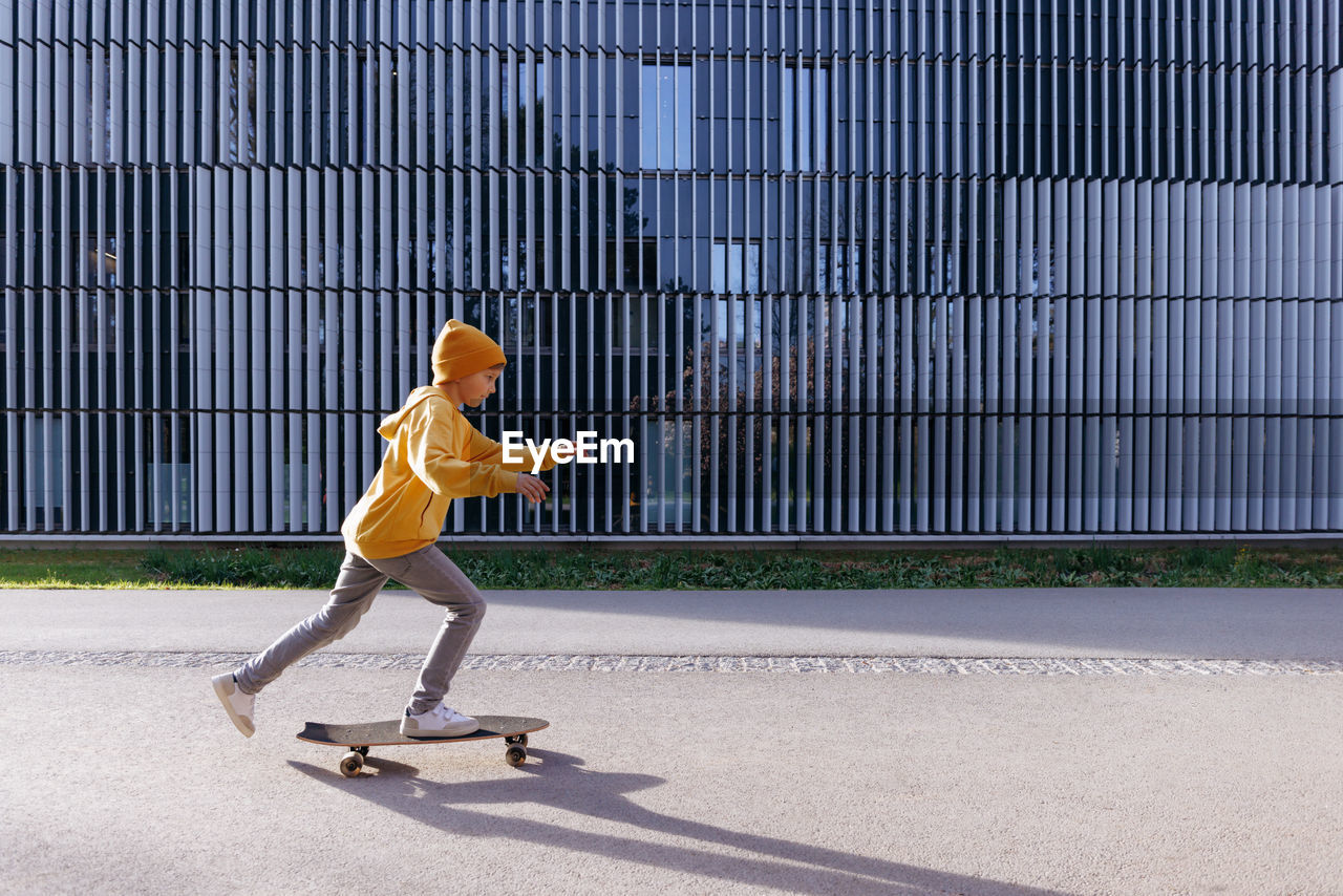 Little boy in casual wear is skating on skateboard. lifestyle concept