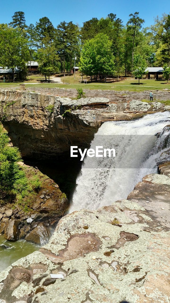 SCENIC VIEW OF WATER FLOWING THROUGH ROCKS