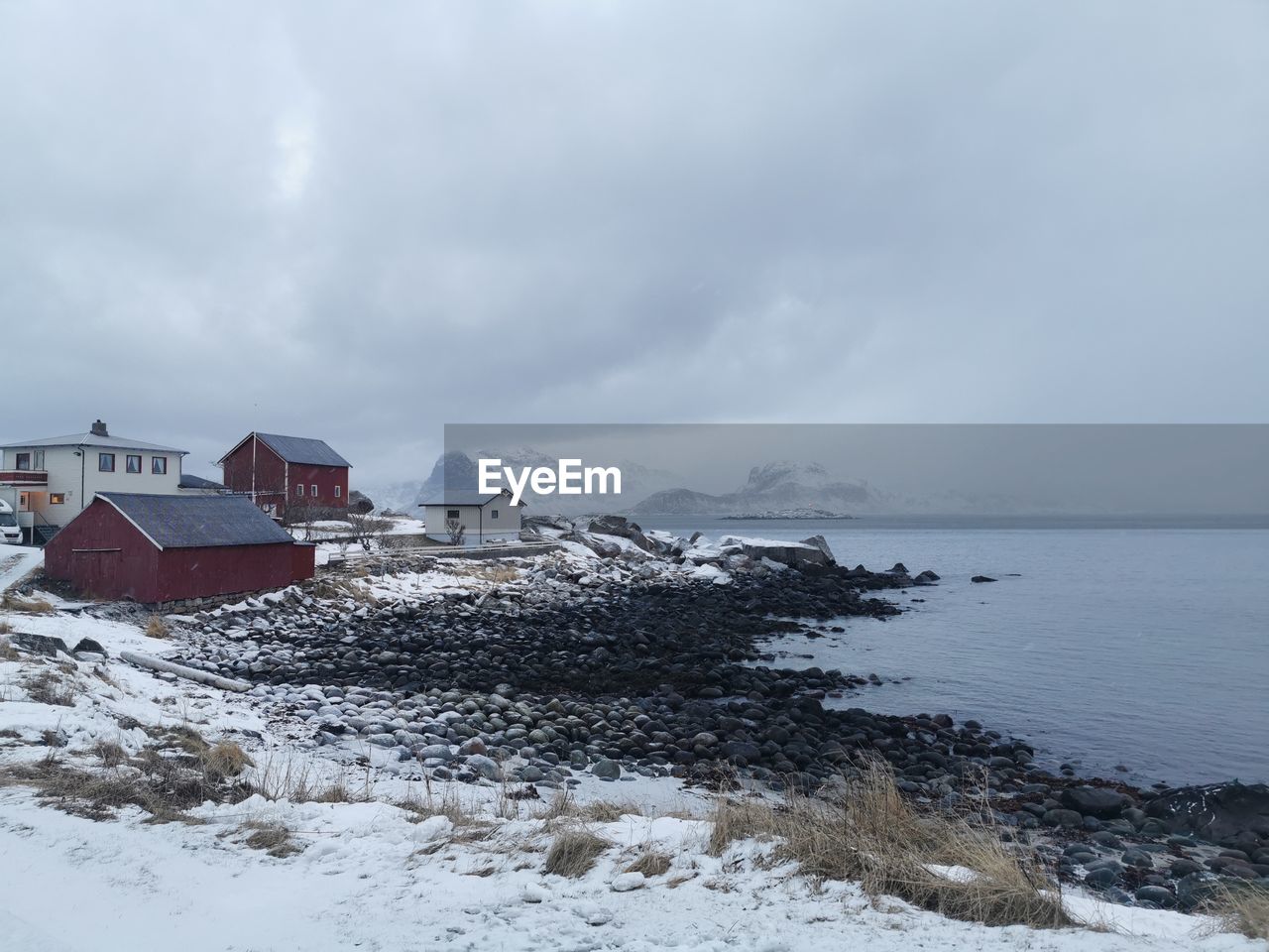 buildings by sea against sky