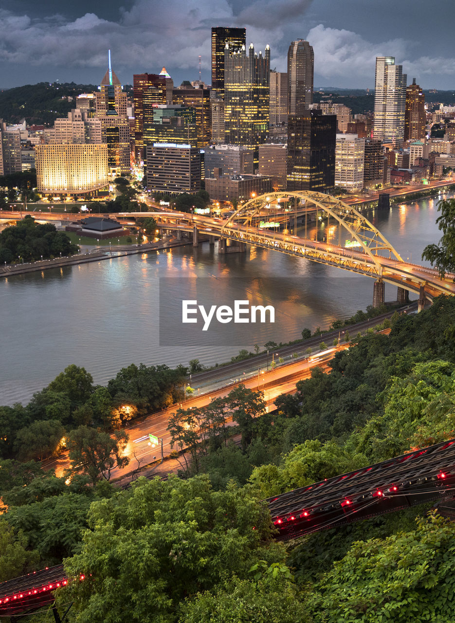 Aerial view of illuminated bridge and buildings against sky