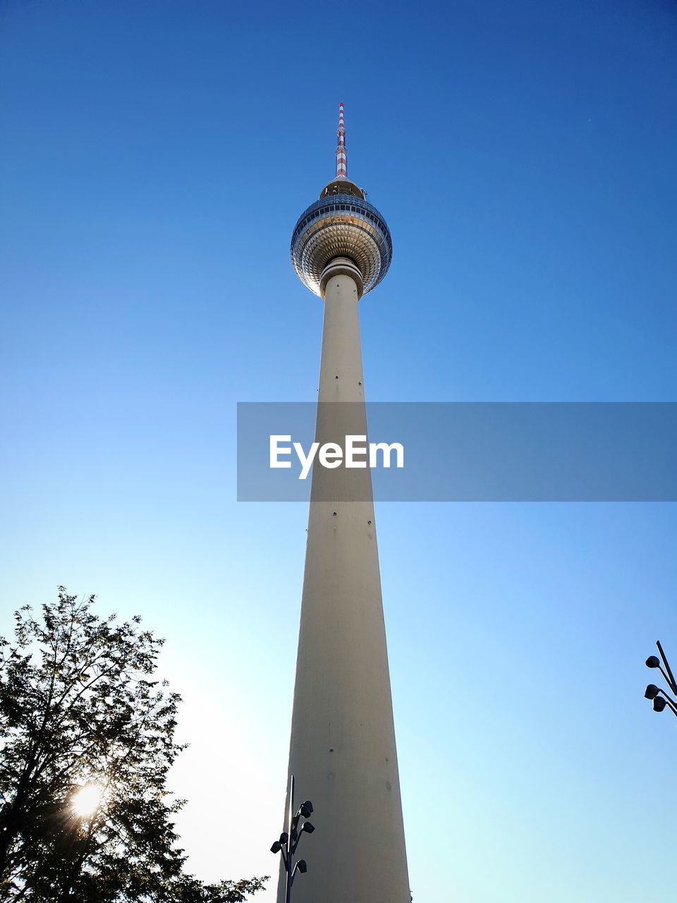 Low angle view of communications tower and building against sky