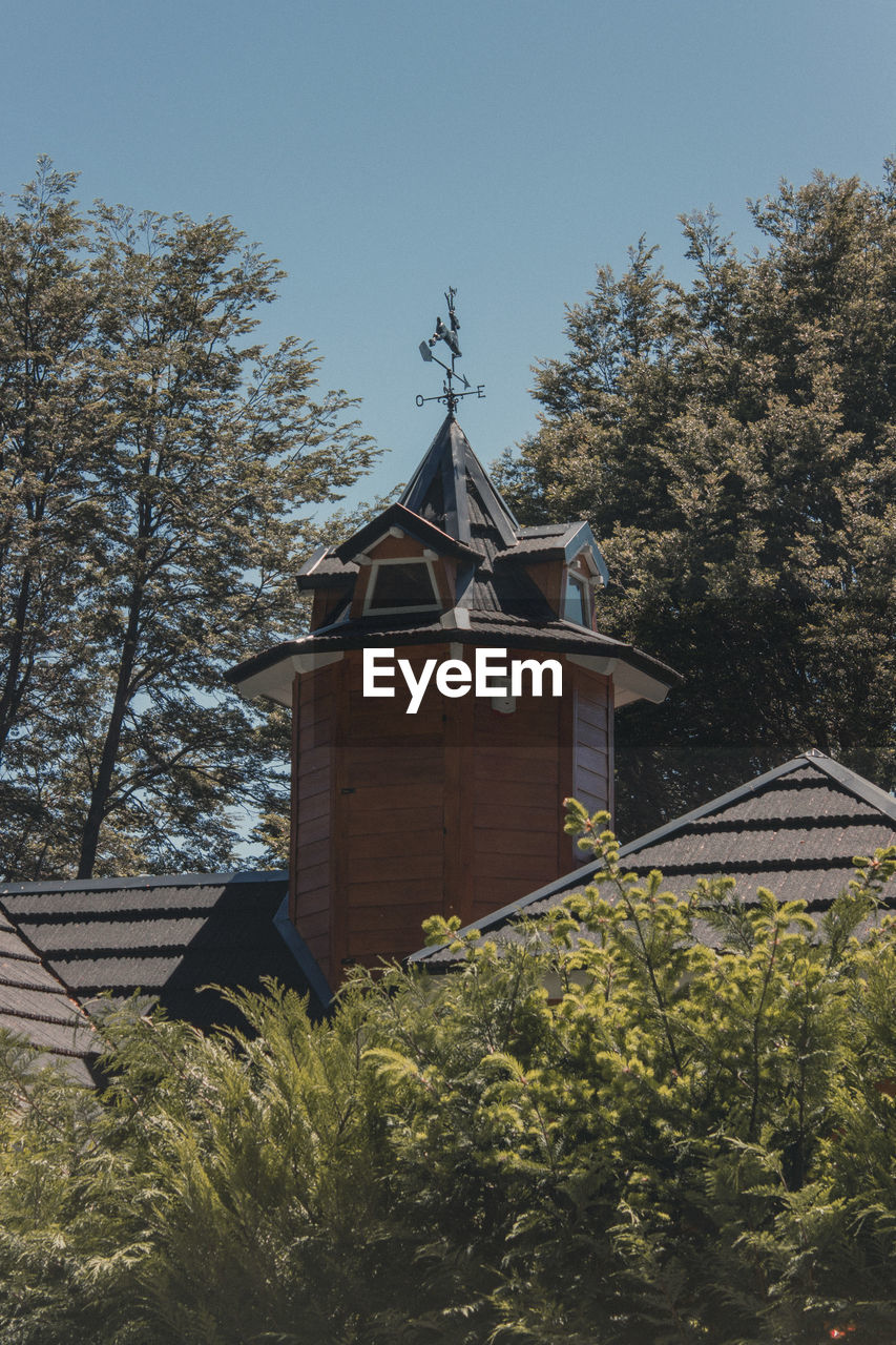 LOW ANGLE VIEW OF BUILDING AND TREES AGAINST SKY