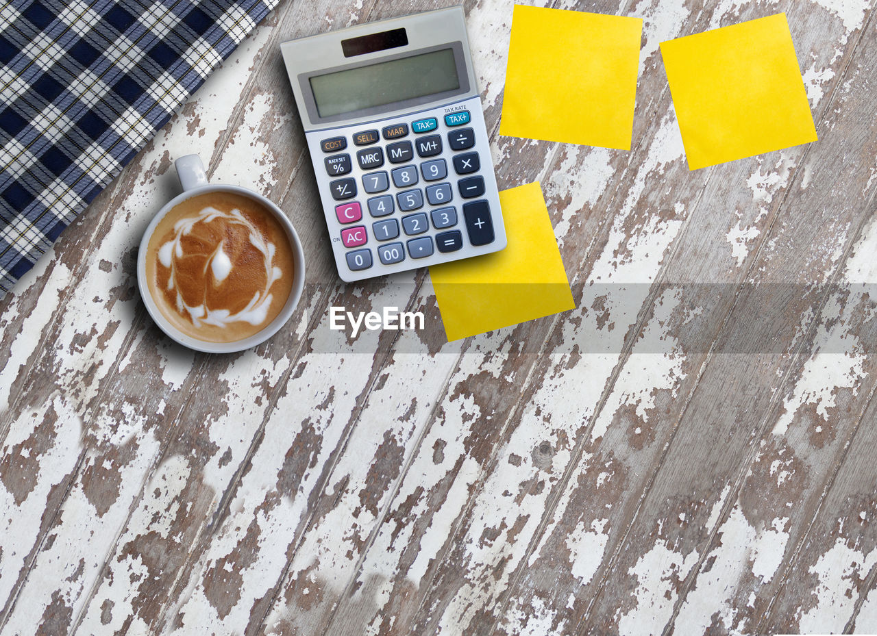 High angle view of coffee and calculator on table