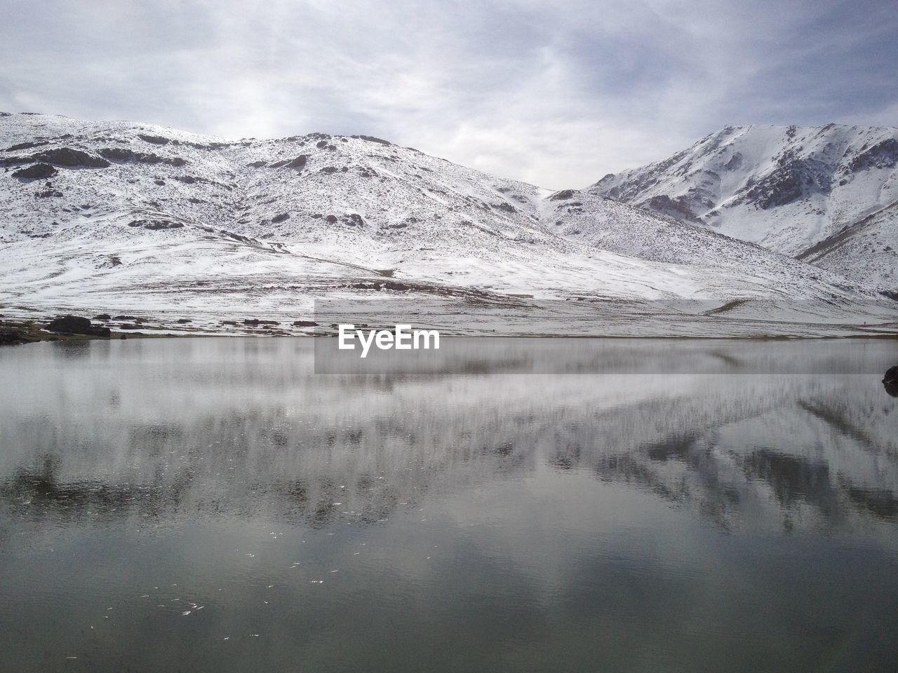 Scenic view of lake and snowcapped mountains against sky