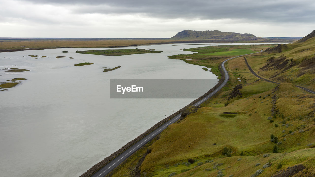 Empty icelandic road on a soggy summer day alongside the glacial river