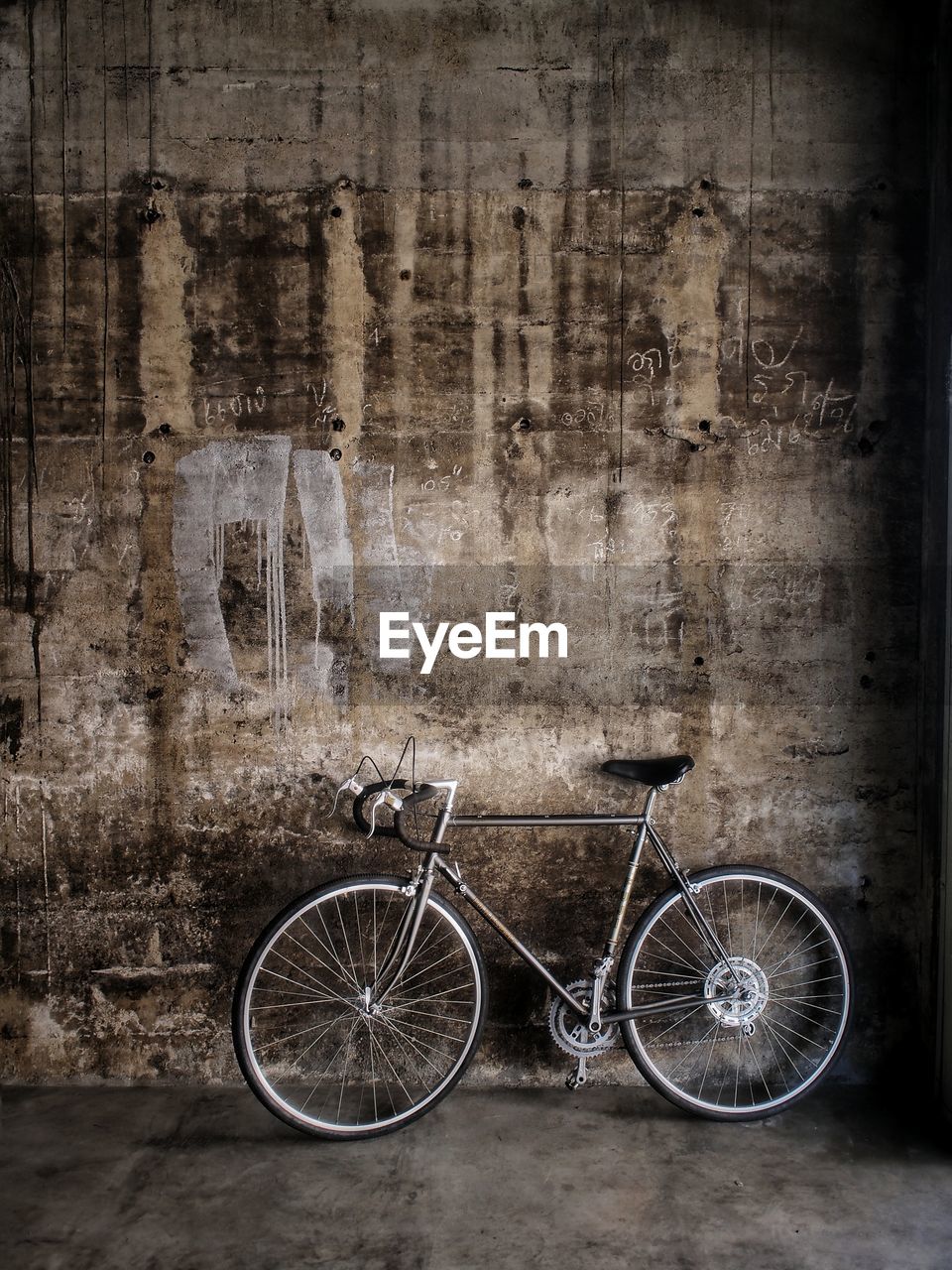 Bicycle parked by old wall