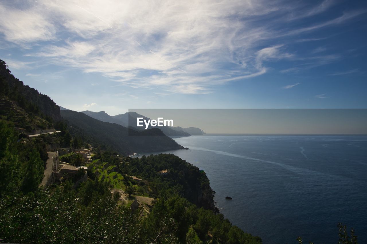 Scenic view of sea and mountains against sky