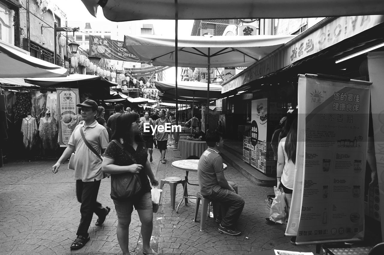 PEOPLE IN TOWN SQUARE AGAINST SKY