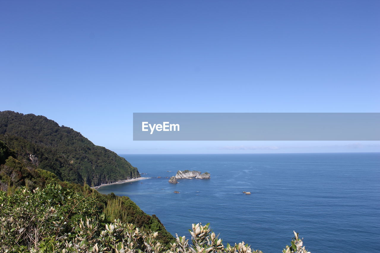 Scenic view of sea against clear blue sky
