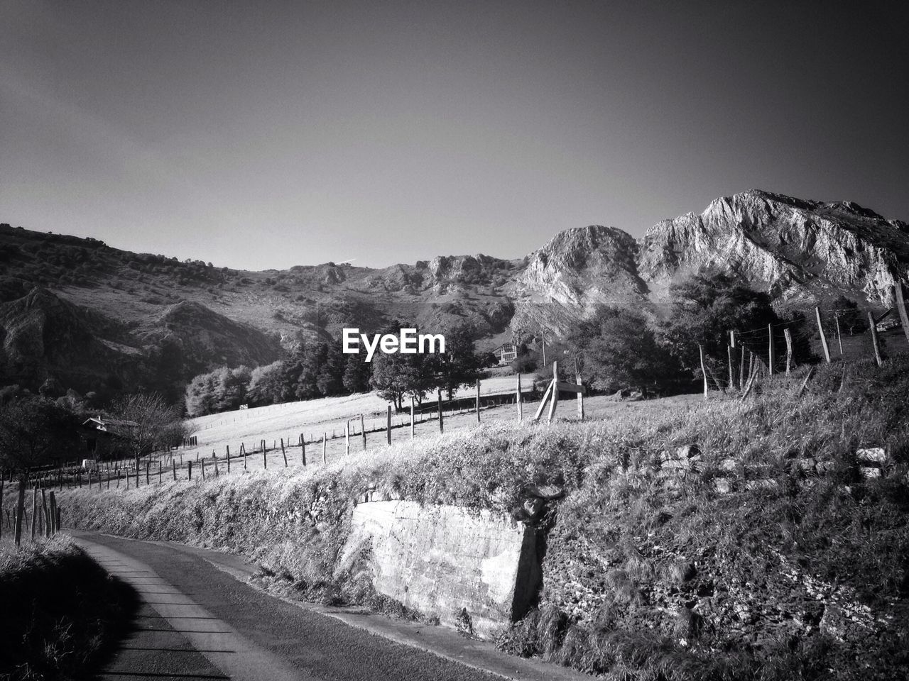 Road leading towards mountains against clear sky