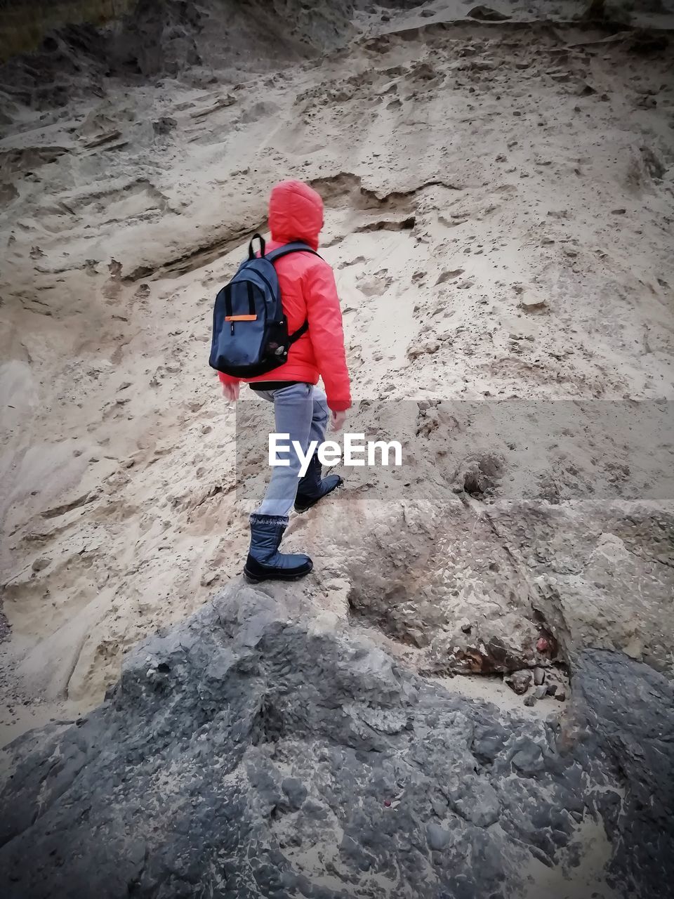Rear view of boy moving up on steep rock