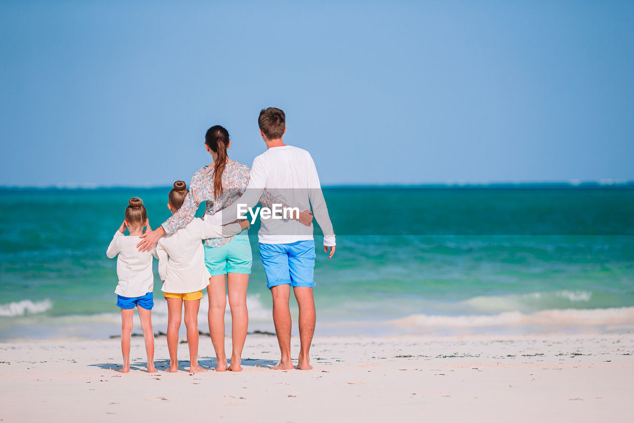 People on beach by sea against sky