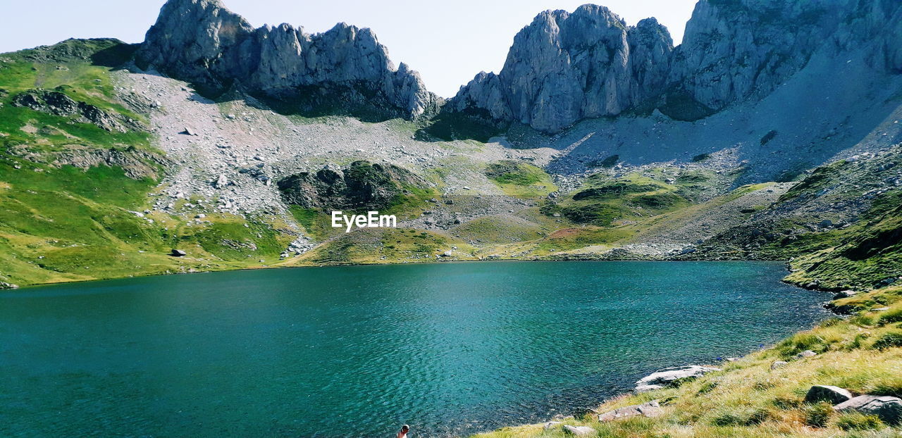 Scenic view of lake by mountains against sky