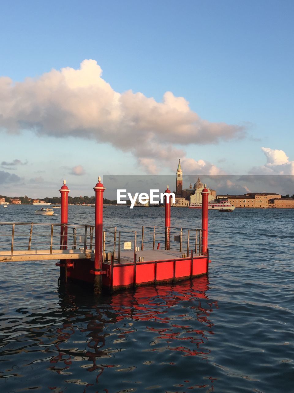 RED WOODEN POST IN SEA AGAINST SKY