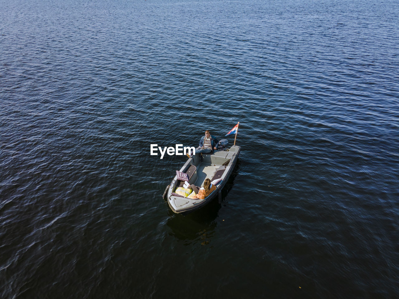 HIGH ANGLE VIEW OF PEOPLE SAILING ON BOAT IN SEA