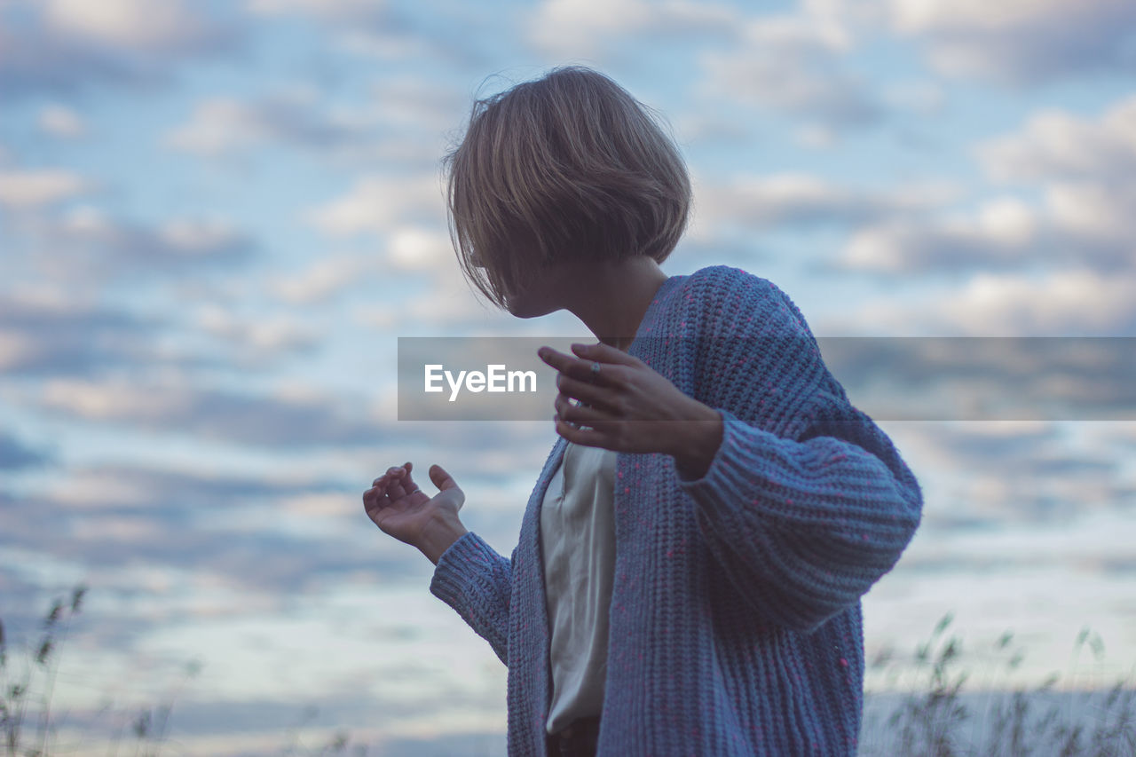 Low angle view of woman dancing against sky