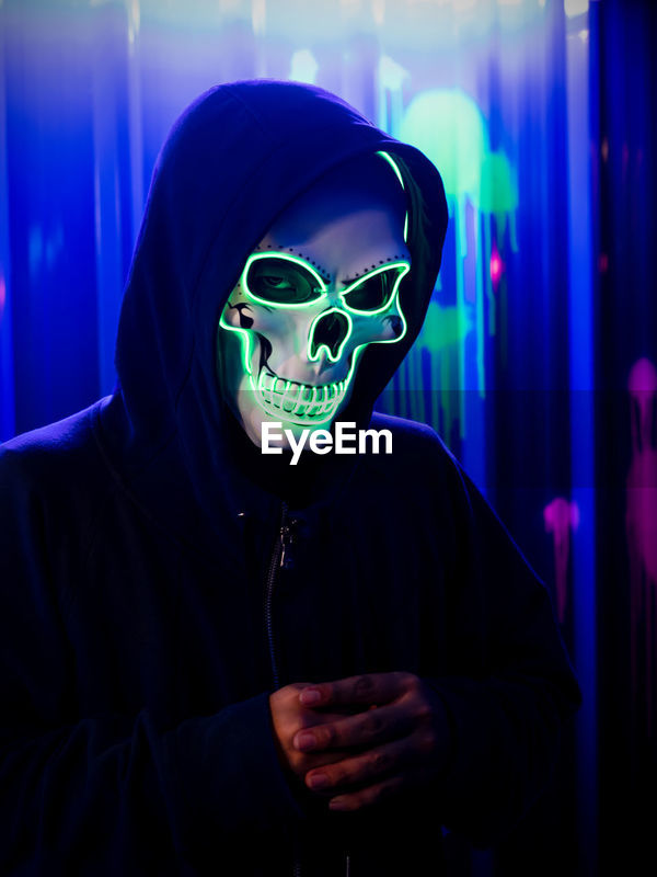 Serial killer wearing neon skull mask at | ID: 168332978