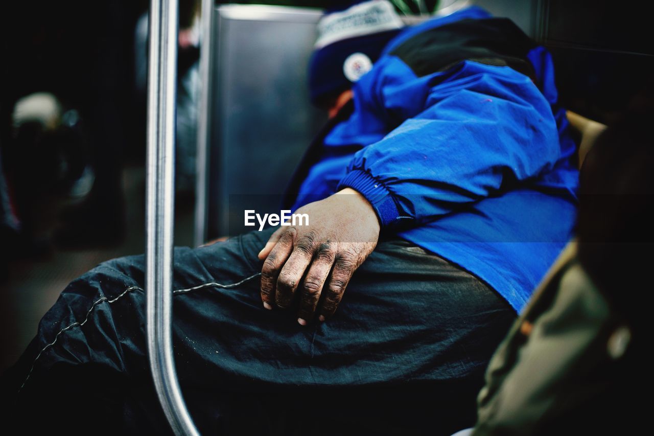 Side view of man sleeping in train