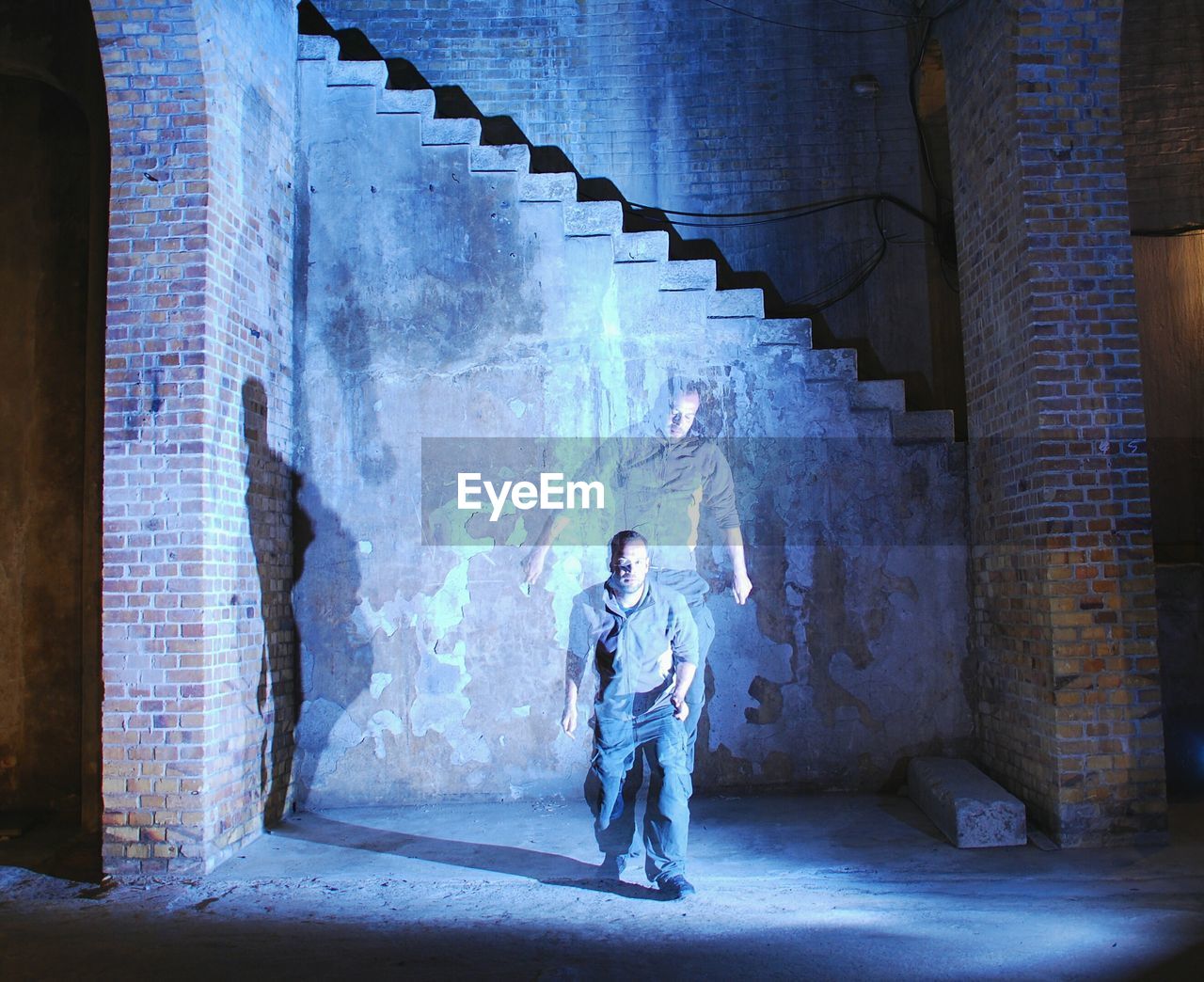 Multiple image of man standing in abandoned building