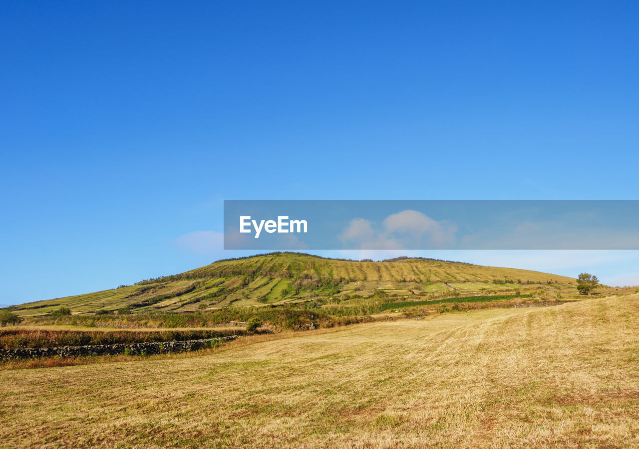 SCENIC VIEW OF ARID LANDSCAPE AGAINST CLEAR BLUE SKY