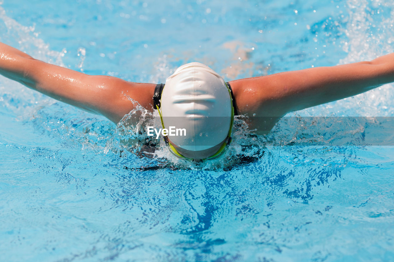 Woman wearing goggles swimming in pool