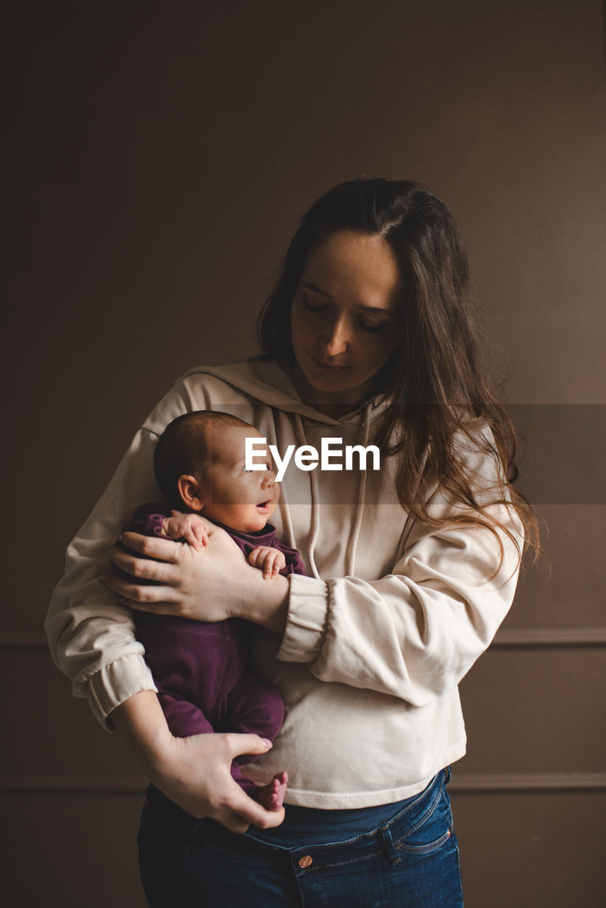 Mother with daughter against wall