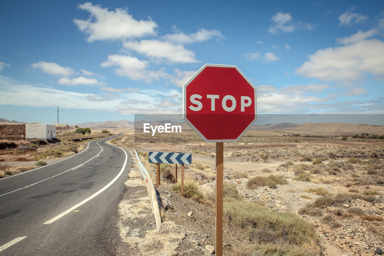 Road sign against blue sky