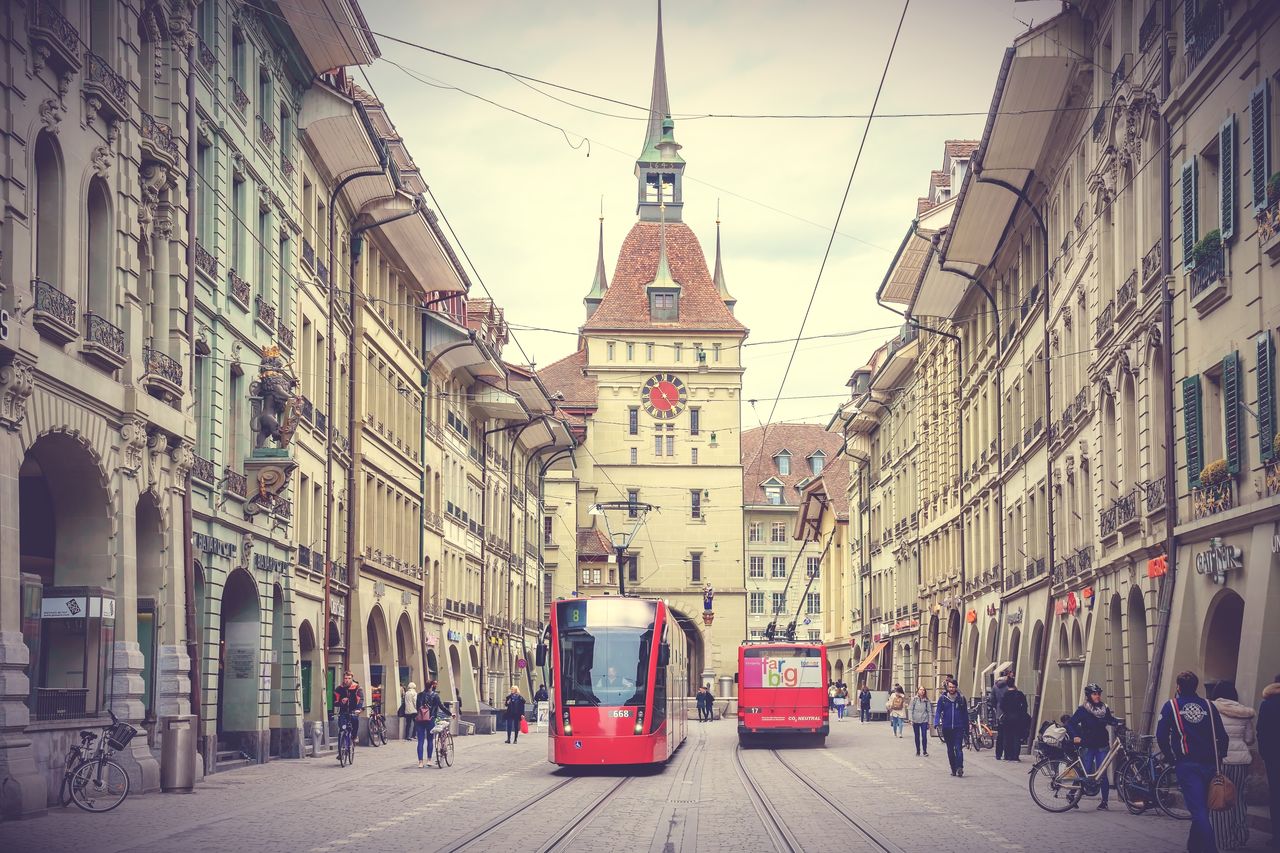 people walking on street amidst buildings in city