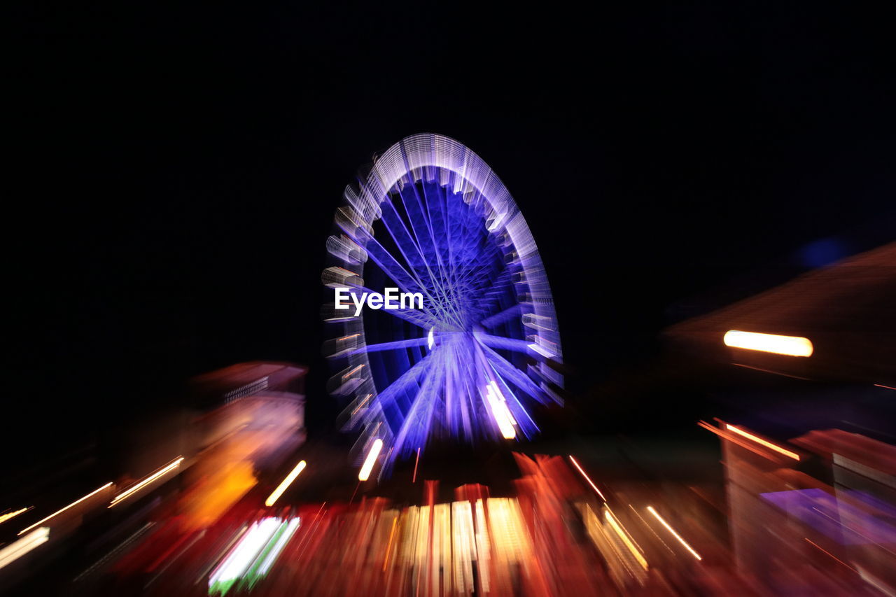 LOW ANGLE VIEW OF FERRIS WHEEL AT NIGHT